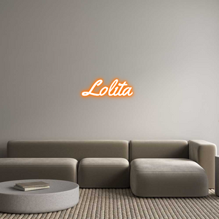 Scritta neon LED personalizzata "Lolita" in font Yellowtail, colore arancione, su parete grigia sopra un elegante divano moderno.