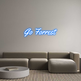 Scritta Neon Led Personalizzata "Go Forrest" in blu con font Yellowtail, su parete salotto minimalista, design elegante.